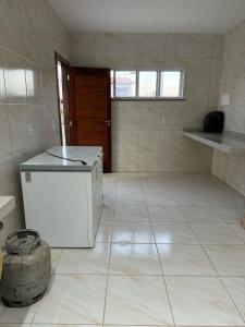 a kitchen with a stove and a refrigerator in a room at Casa Paraiso in Beberibe