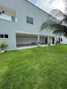 a large building with a grass yard in front of it at Casa Paraiso in Beberibe