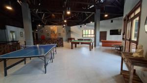 een kamer met 2 tafeltennistafels en een bank bij Ilha Flat 4-106 in Ilhabela