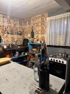 cocina con fogones y mesa con encimera en Pousada pantera do rosa, en Imbituba