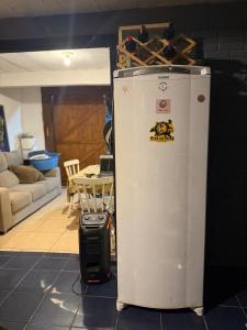 Un refrigerador y una maleta en una sala de estar. en Pousada pantera do rosa, en Imbituba