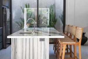 ラワイビーチにあるAndaman Paradise 1 - Luxury 3-Bedrooms Pool Villaのキッチン(シンクと椅子付きのカウンター付)