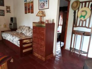a bedroom with a dresser and a bed and a desk at Cabaña Catelmo in Colalao del Valle