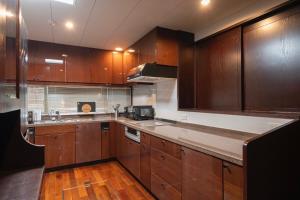 eine Küche mit Holzschränken und einer Arbeitsplatte in der Unterkunft Alphabed Villa Waka - Vacation STAY 17109 in Takamatsu