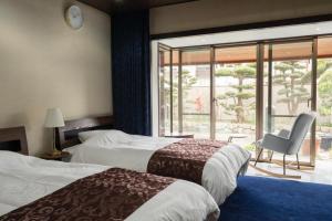 ein Hotelzimmer mit zwei Betten und einem Stuhl in der Unterkunft Alphabed Villa Waka - Vacation STAY 17109 in Takamatsu + 49 Fotos