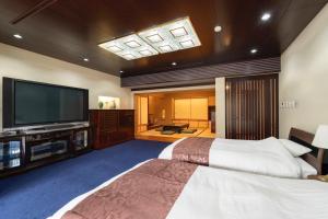 ein Schlafzimmer mit großem Bett und Flachbildfernseher in der Unterkunft Alphabed Villa Waka - Vacation STAY 17109 in Takamatsu