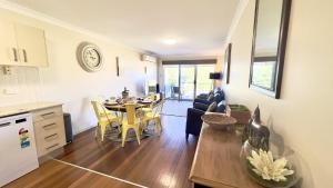 a kitchen and living room with a table and chairs at Seaspray Breeze - Lifestyle Yamba in Yamba