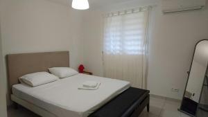 a bedroom with a white bed with two towels on it at Appartement 2 pièces proche centre Commercial Galléria in Le Lamentin