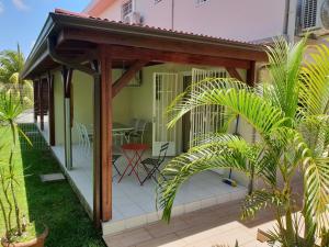 a pergola on a house with a table at Appartement 2 pièces proche centre Commercial Galléria in Le Lamentin