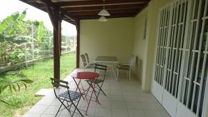 a patio with a table and chairs on it at Appartement 2 pièces proche centre Commercial Galléria in Le Lamentin