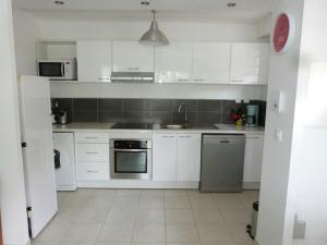 a white kitchen with white cabinets and a sink at Appartement 2 pièces proche centre Commercial Galléria in Le Lamentin