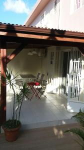 a patio with chairs and a table on a house at Appartement 2 pièces proche centre Commercial Galléria in Le Lamentin +4 photos