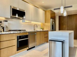 a kitchen with stainless steel appliances and wooden cabinets at CONDO FRENTE AL MAR Hermoso con amenidades in Bucerías +26 photos