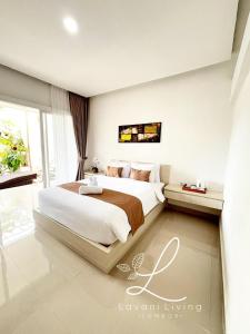 een slaapkamer met een groot bed en een groot raam bij Lavani Living Hotel in Tjakranegara +4 foto's