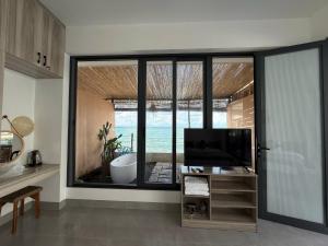 a living room with a tv and a large window at Seaside Mui Ne Hotel in Mui Ne