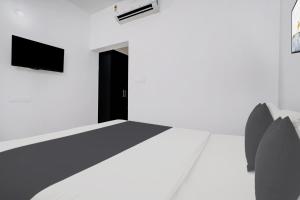 Una televisión o centro de entretenimiento en Hotel O EVA RESIDENCY 26 fotos más