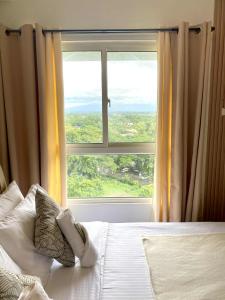 a bedroom with a bed with a large window at H4R1 Luxe Haven in Bacolod