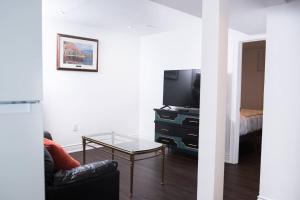 a living room with a tv and a glass table at Comfortable Two Bedroom Basement Suite with Full Kitchen Bathroom and Queen Beds in Richmond Hill