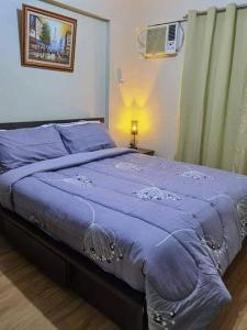 a bedroom with a bed with a blue blanket at Asteria Residences Paranaque Sucat 2 Bedroom in Sampong