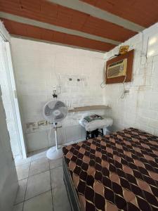 a bedroom with a bed and a fan in a room at Casa chalé em Tamandaré in Tamandaré +8 photos