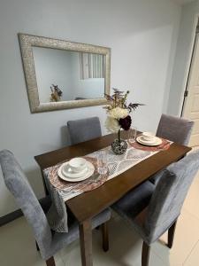 a dining room table with chairs and a mirror at Tivoli Condominium in Cebu City