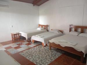 Zimmer mit 2 Betten und Fliesenboden in der Unterkunft Cabinas Aventura in Ojo de Agua