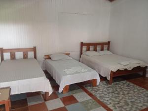 a room with two beds and a rug at Cabinas Aventura in Ojo de Agua +22 photos
