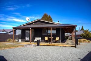Casa negra con terraza con mesa y sillas en No3onfraser, en Twizel