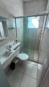 a bathroom with a shower and a toilet and a sink at Casa Praia dos Anjos in Arraial do Cabo