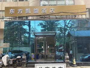 un bâtiment avec une enseigne au sommet dans l'établissement 东方凯旋酒店北京南站店, à Pékin