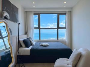 a bedroom with a bed and a large window at Sea Breeze Apartment - The Song Căn Hộ Du Lịch Biển Vũng Tàu in Vung Tau