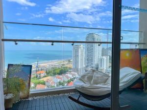a balcony with a bed and a view of the city at Sea Breeze Apartment The Sóng-View Biển & Hồ Bơi Resort Vũng Tàu in Vung Tau