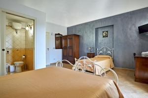 a bedroom with two beds and a bathroom at Agriturismo Conte Ruggero in Centuripe