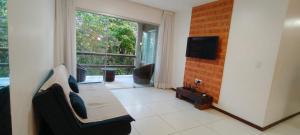 un soggiorno con un divano e una grande finestra di Quarto e sala pratagy a Maceió