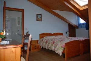 a bedroom with a bed and a desk and a window at Agriturismo Ae Noseare in Torri di Quartesolo