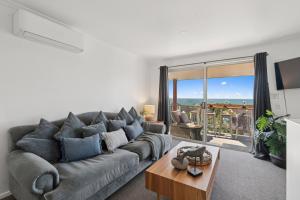un salon avec un canapé gris et une table dans l'établissement Ocean Edge - Resort Pool, Tennis, Bbq, Beach, à Sapphire Beach