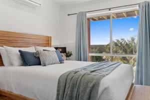 une chambre avec un grand lit avec une grande fenêtre dans l'établissement Ocean Edge - Resort Pool, Tennis, Bbq, Beach, à Sapphire Beach