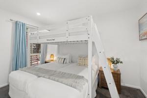 une chambre avec un lit superposé blanc avec une échelle dans l'établissement Ocean Edge - Resort Pool, Tennis, Bbq, Beach, à Sapphire Beach