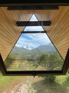 a window in a roof with a view of mountains at OUTSCAPE l Hermosa Cabaña en Parque Nacional Cerro Castillo in Villa Cerro Castillo