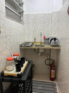 een kleine keuken met een aanrecht en een kookplaat bij Loft no Centro- Lapa, Consulado, Praia,Metrô e AR! 605 in Rio de Janeiro