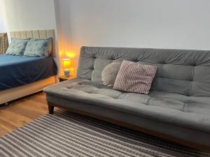 een grijze bank met een knuffelbeer erop bij Loft no Centro- Lapa, Consulado, Praia,Metrô e AR! 605 in Rio de Janeiro