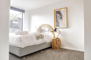 Un dormitorio con una cama y un cuadro en la pared. en Spacious and Convenient - Azure Retreat, en Bicheno