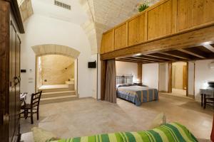 ein Schlafzimmer mit einem Bett und einem Schreibtisch in einem Zimmer in der Unterkunft Tre Volte Belle in Carpignano Salentino
