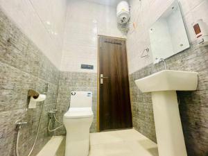 a bathroom with a toilet and a sink at Hasrat Residency in Jagādhri