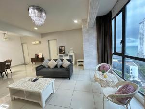 a living room with a couch and a table at Deluxe Seaview Suite Tripe Bed with bath tub 13A in Tanjong Tokong