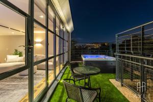 a balcony with a table and chairs and a hot tub at AYLI - Kensington in London