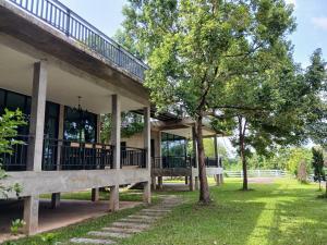 a building with a tree in front of it at Black Bears Resort & Onsen in Ban Thung Lakhon