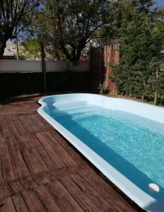 a swimming pool on a wooden deck next to at El Durazno Apart Hotel y Cabañas in San Pedro