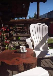 a white chair and a coffee cup on a table at El Durazno Apart Hotel y Cabañas in San Pedro