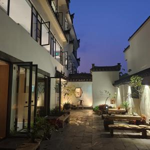 a courtyard of a building with tables and benches at Huiyuan Mansion Guangzhou in Guangzhou